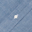 The closeup of the blue placket of the work shirt with a white button.