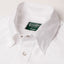 A close up of the white button under collar with a pearl snap button, green gitman vintage tag.