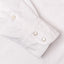 a white sleeve with two pearl snap buttons and a white button.