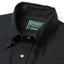A close up of the black button under collar with a pearl snap button, green gitman vintage tag.