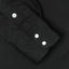 a black sleeve with two pearl snap buttons and a white button.