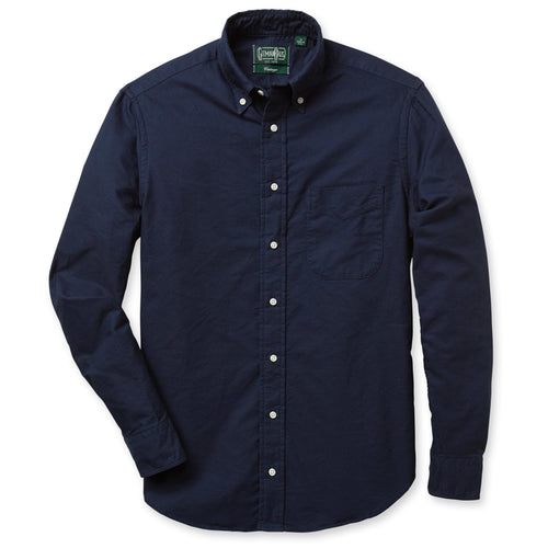 A navy-colored, button down 100% cotton Oxford shirt with a chest pocket and barrel cuffs, and slim fit.